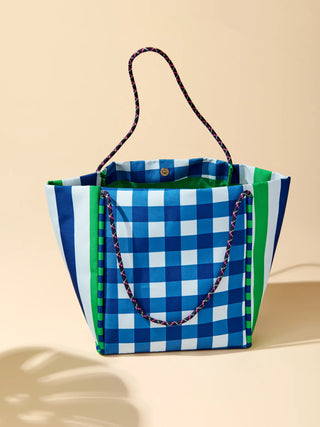 Colorful checkered tote bag with a striped handle on a beige background