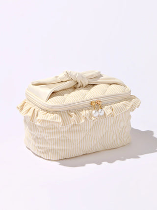 Cream-colored cosmetic bag with ruffles and a bow on a white background