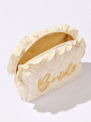 Cream-colored clutch bag with 'Bride' embroidery on a light gray background