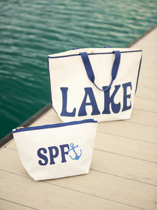 Two bags with 'LAKE' and 'SPF' text on a dock by water