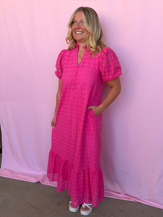 Woman wearing a pink dress against a pink background