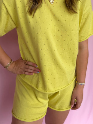 Person wearing a yellow outfit with a pink background