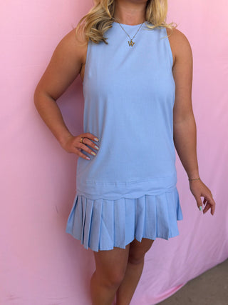 Woman wearing a light blue dress against a pink background