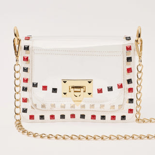 White handbag with colorful studs and a gold chain strap on a light gray background