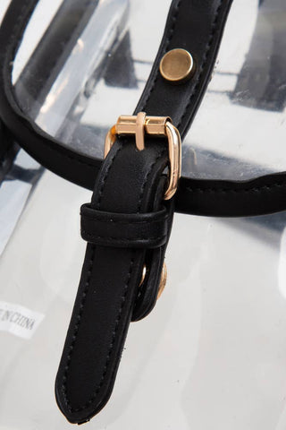 Close-up of a black strap with a rose gold buckle on a clear bag.