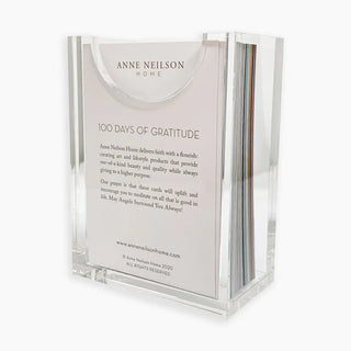 Clear acrylic holder with 'Anne Neilson Home' cards inside on a white background