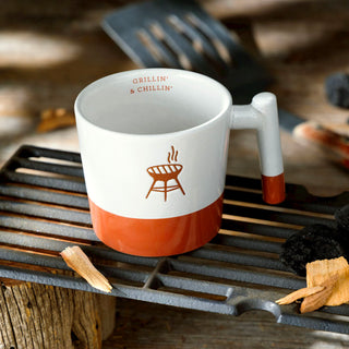 White and orange mug with grill design on a grill