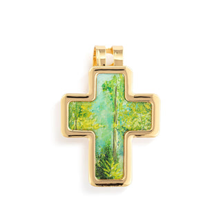 Gold cross pendant with a nature scene design on a white background