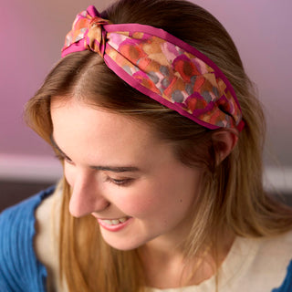 Woman wearing a colorful patterned headband with a blurred background