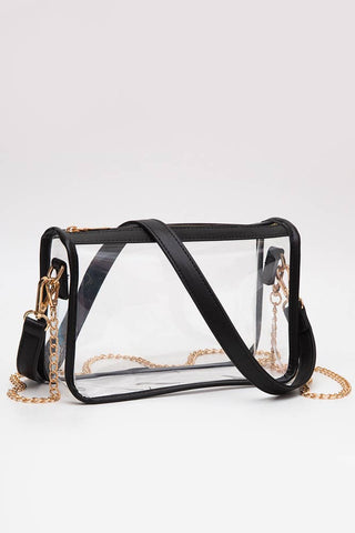 Clear handbag with black straps and gold chain on a white background