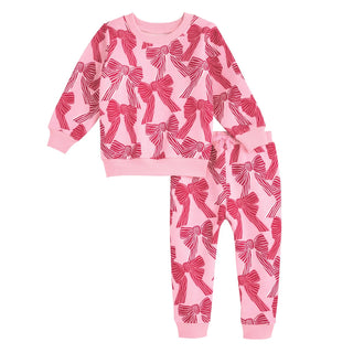 Pink children's outfit with bow pattern on a white background