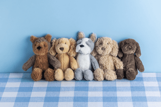 Five stuffed animals sitting together on a blue checkered fabric