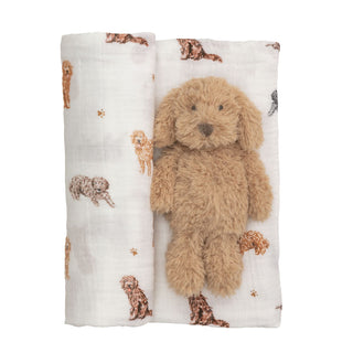 Plush dog toy on a white blanket with dog pattern