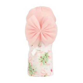 Pink turban with a white fabric swaddle featuring green and red patterns on a white background