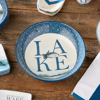 Decorative plate with 'LAKE' and fish design on a wooden table