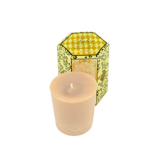 Votive candle with a lit wick in front of a decorative box on a white background
