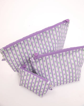 Three lavender and white striped zipper pouches with a small green floral pattern, arranged by size on a white background.