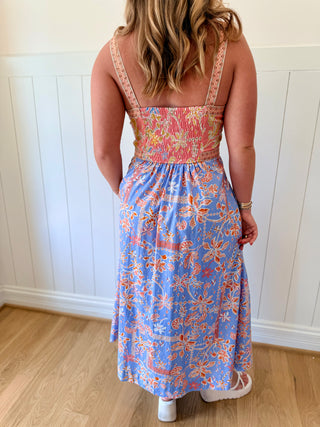 Woman wearing a floral dress with a white wall background