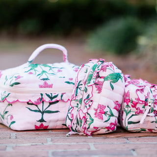 Floral-patterned bags on a wooden surface with a blurred natural background