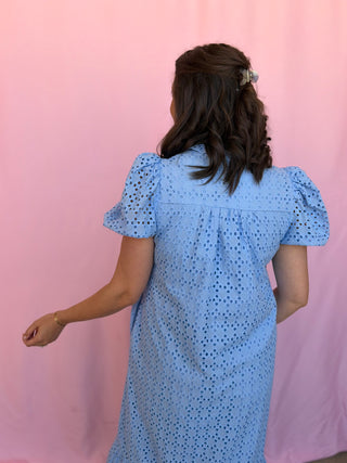 Woman wearing a blue dress with a pink background