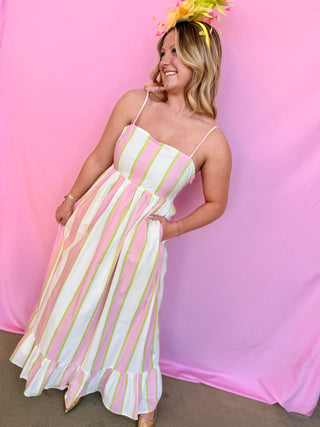 Woman wearing a pink and white striped dress against a pink background
