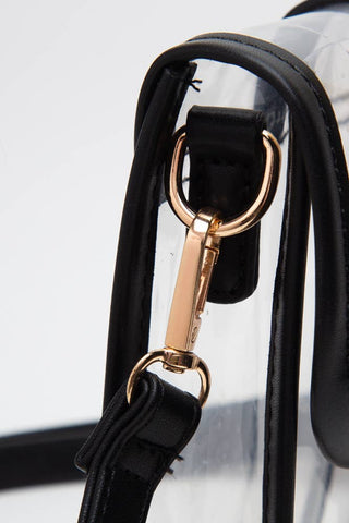 Close-up of a black handbag strap with gold hardware on a white background