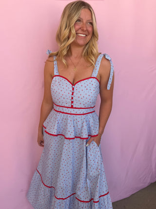 Woman wearing a blue striped with red trim against a pink background