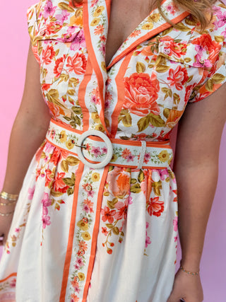 Floral dress with a belt on a pink background