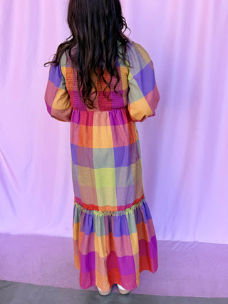 girl wearing plaid dress on a pink background