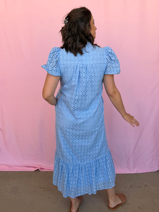 Woman wearing a blue dress with a pink background