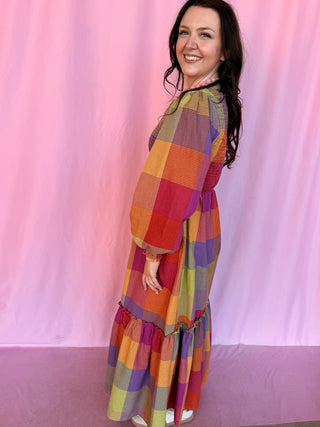 girl wearing plaid dress on a pink background