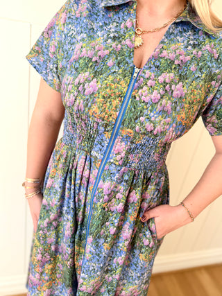 Person wearing a floral dress with a zipper detail.