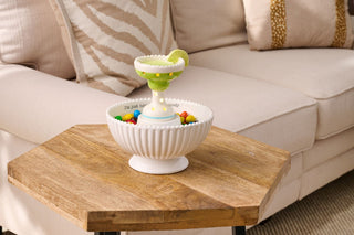Decorative bowl with colorful items on a wooden coffee table in a living room setting.