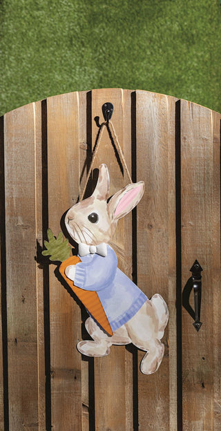 Decorative door hanger of a rabbit holding a carrot on a wooden background