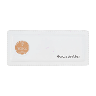 Rectangular white napkin with a circular label and 'Goodie Grabber' text on a white background