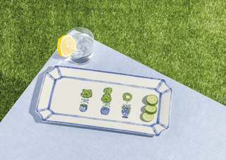 Decorative tray with plant designs on a grassy background