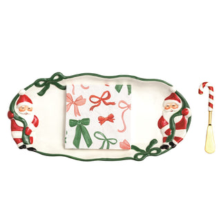 Decorative tray with Santa Claus design, candy cane, and spoon on a white background
