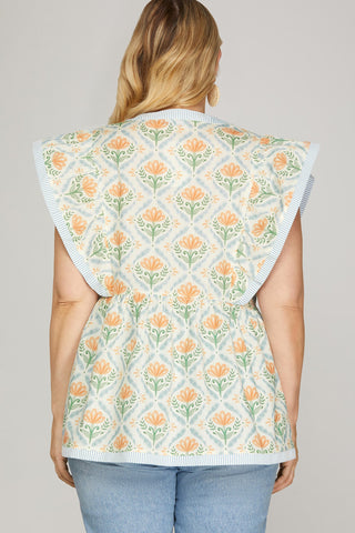 Person wearing a floral patterned vest on a plain background