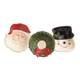 Three ceramic Christmas-themed items including a Santa face, wreath with a bow, and a snowman face on a white background.