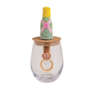 Decorative glass with a cork stopper and a small bottle on top, all on a white background