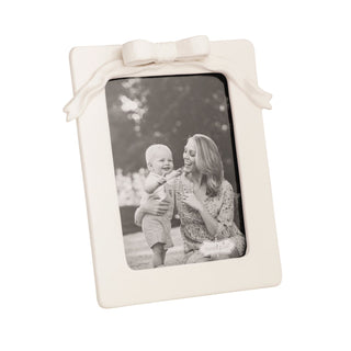 White photo frame with a bow on a white background