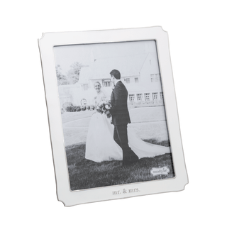 White photo frame with a black and white photograph of a couple on a grassy area.