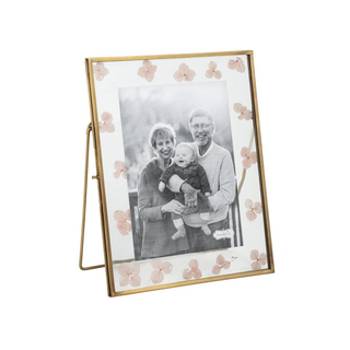 Gold photo frame with floral design holding a black and white family photo on a white background