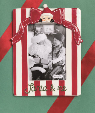 Decorative photo frame with red and white stripes, Santa Claus design, and black and white photo of a child and Santa.