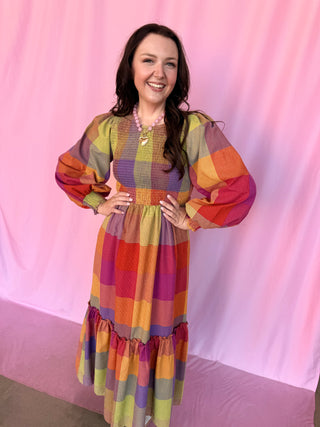 girl wearing plaid dress on a pink background