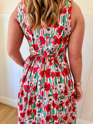 Person wearing a floral dress with red poppy pattern indoors.