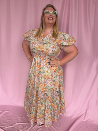 Woman wearing a floral dress against a pink background