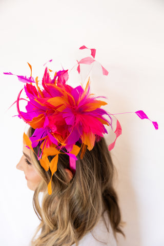 Woman wearing a colorful feather headpiece against a white background