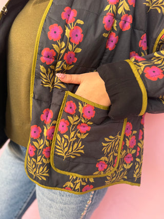 Black jacket with floral embroidery on a pink background