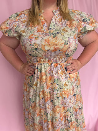 Woman wearing a floral dress against a pink background